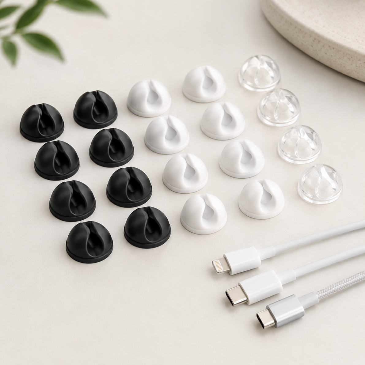 Twenty cable organizer clips in transparent, white and black laid out flat